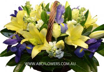BA002 Cremorne A Basket Flower Arrangement of white roses, yellow lilies, white flowers, and purple flowers